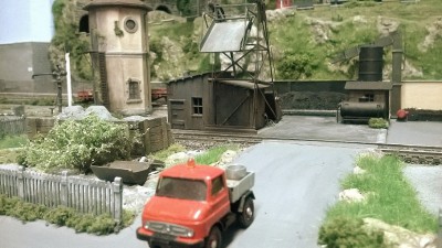 Zona carbonaia,con caricatore di carbone per locomotive autocostruito in metallo (ottone ) e legno. Sul fondo si vede  un dispositivo meccanico per il  sollevamento del carbone scaricato da camions,  portato dentro la zona di carico locomotive.